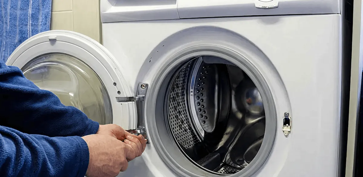 Washing machine repair handyman checking a front-load washer door and latch in New Orleans, LA
